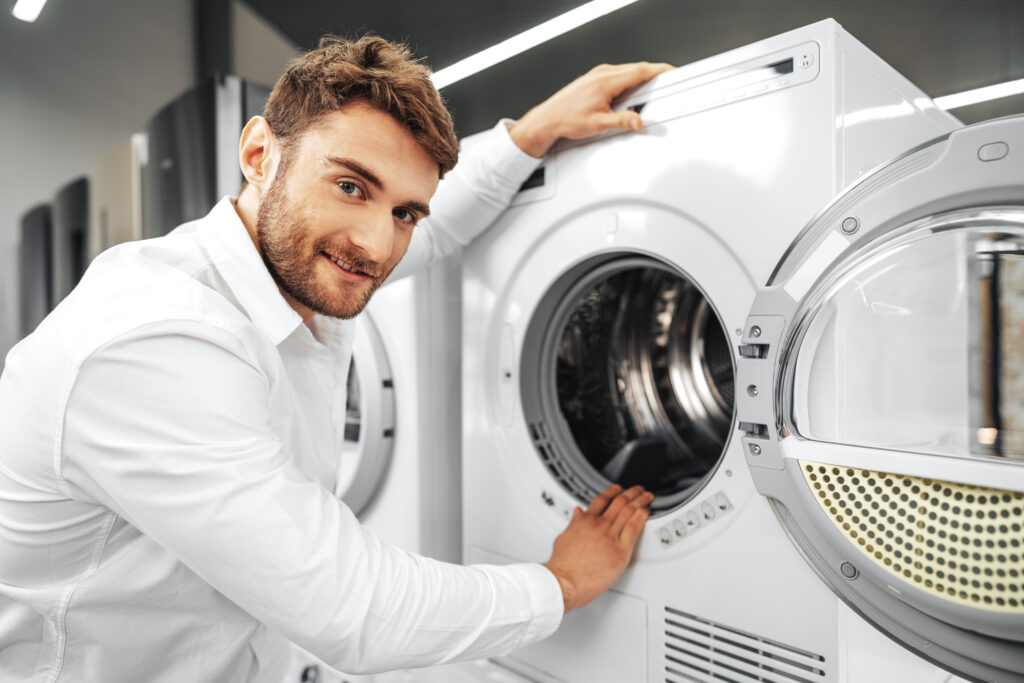 Young Man Choosing New Washing Machine Household Appliances Store 1024x683